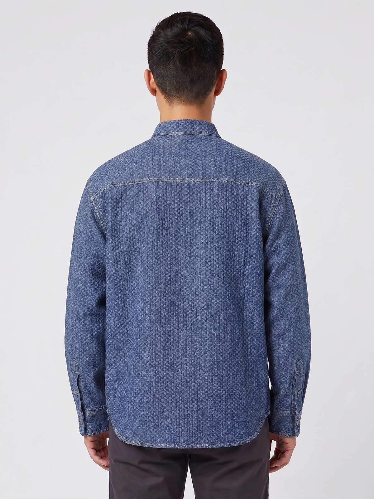Man wearing a blue patterned shirt on a white background