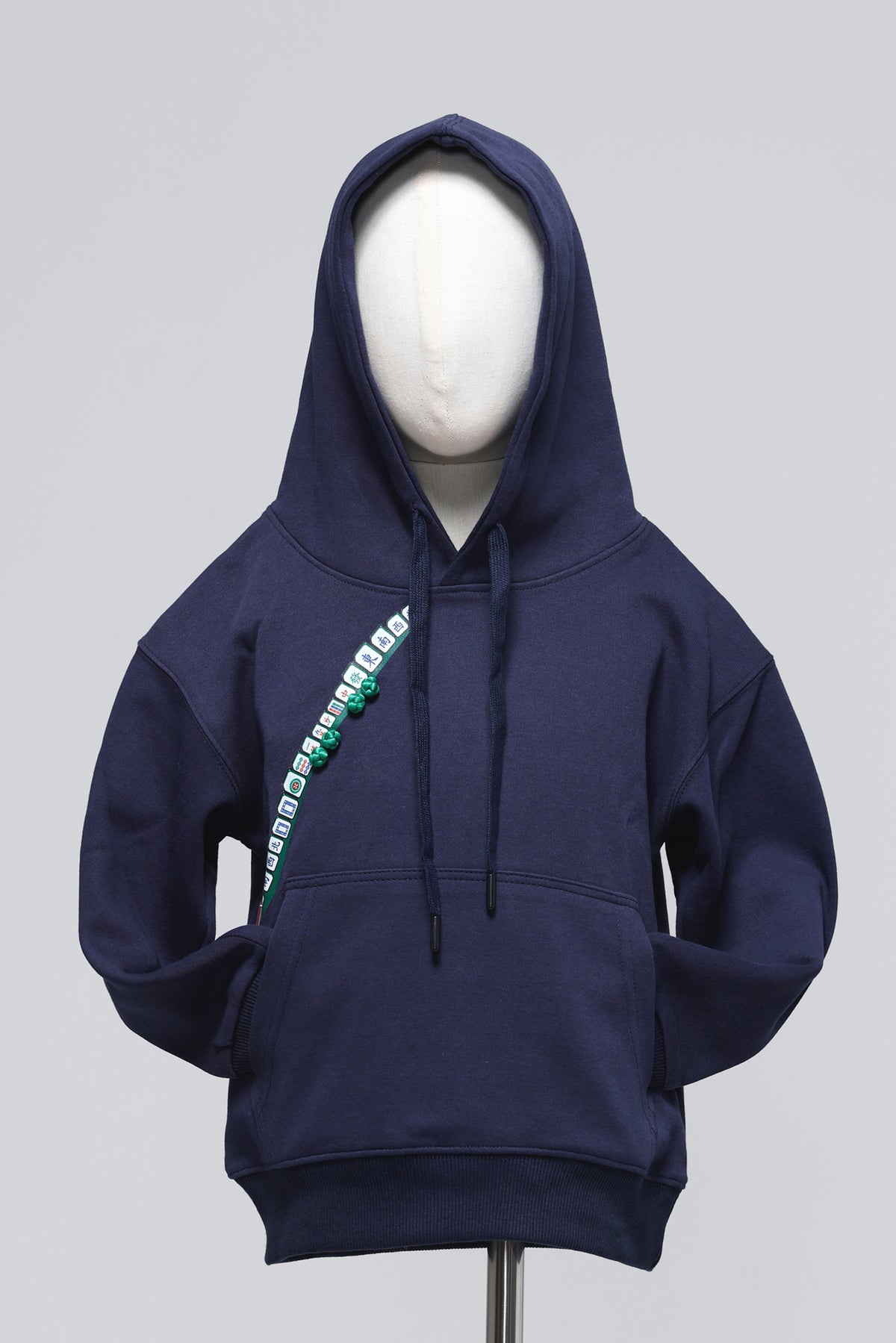 A navy blue pullover hoodie displayed on a white mannequin torso against a light gray background. The hoodie features a diagonal graphic print on the chest with green and white lettering.