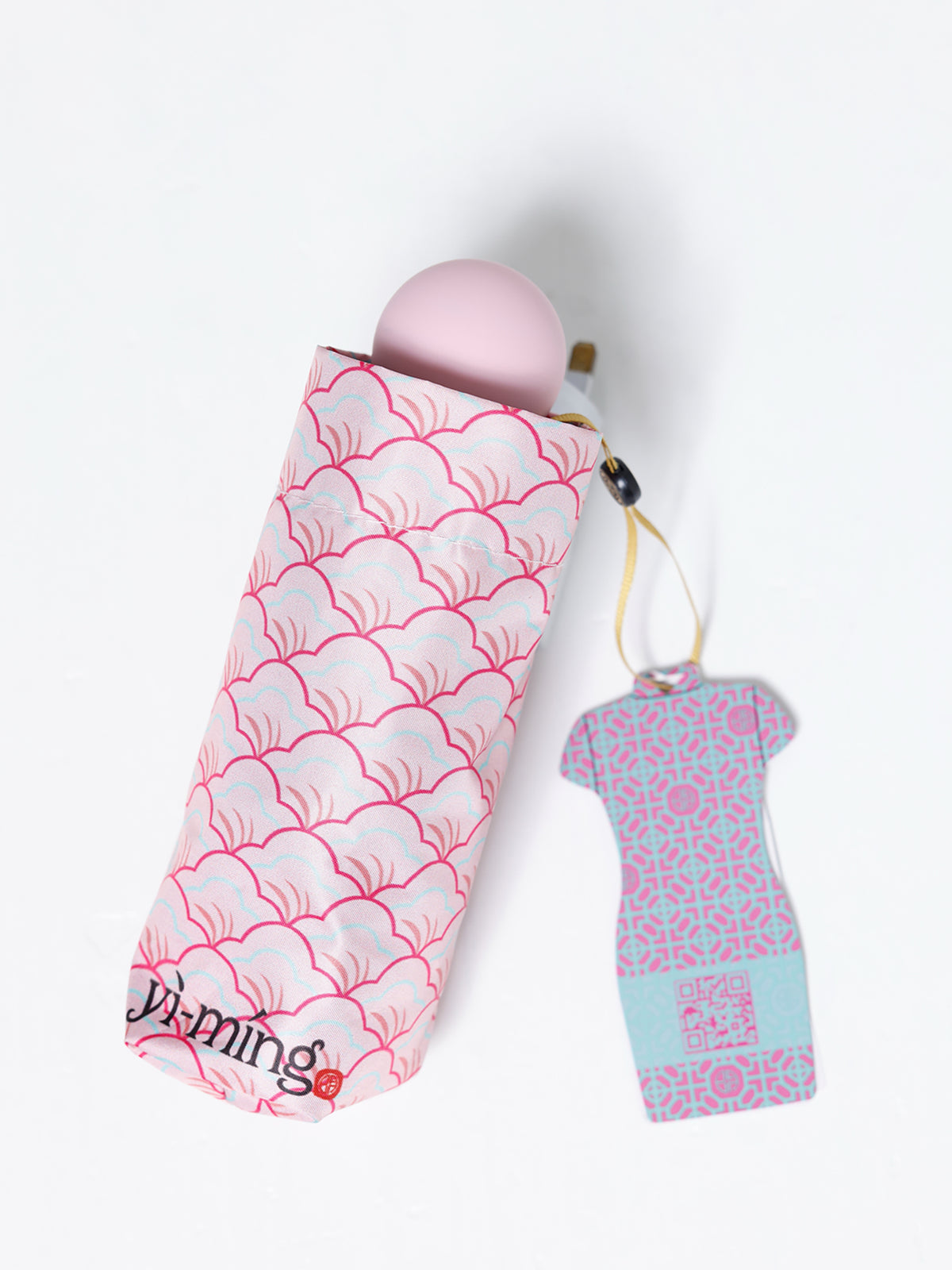 A folded pink umbrella in a pink wave-patterned sleeve
