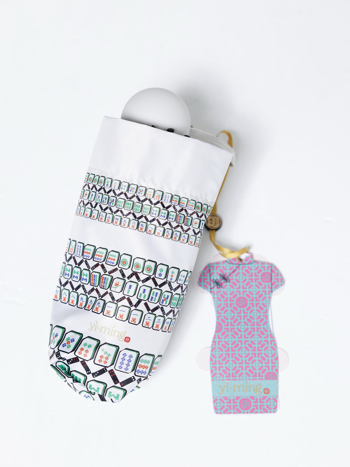 A folded white umbrella with a colorful mahjong tile pattern