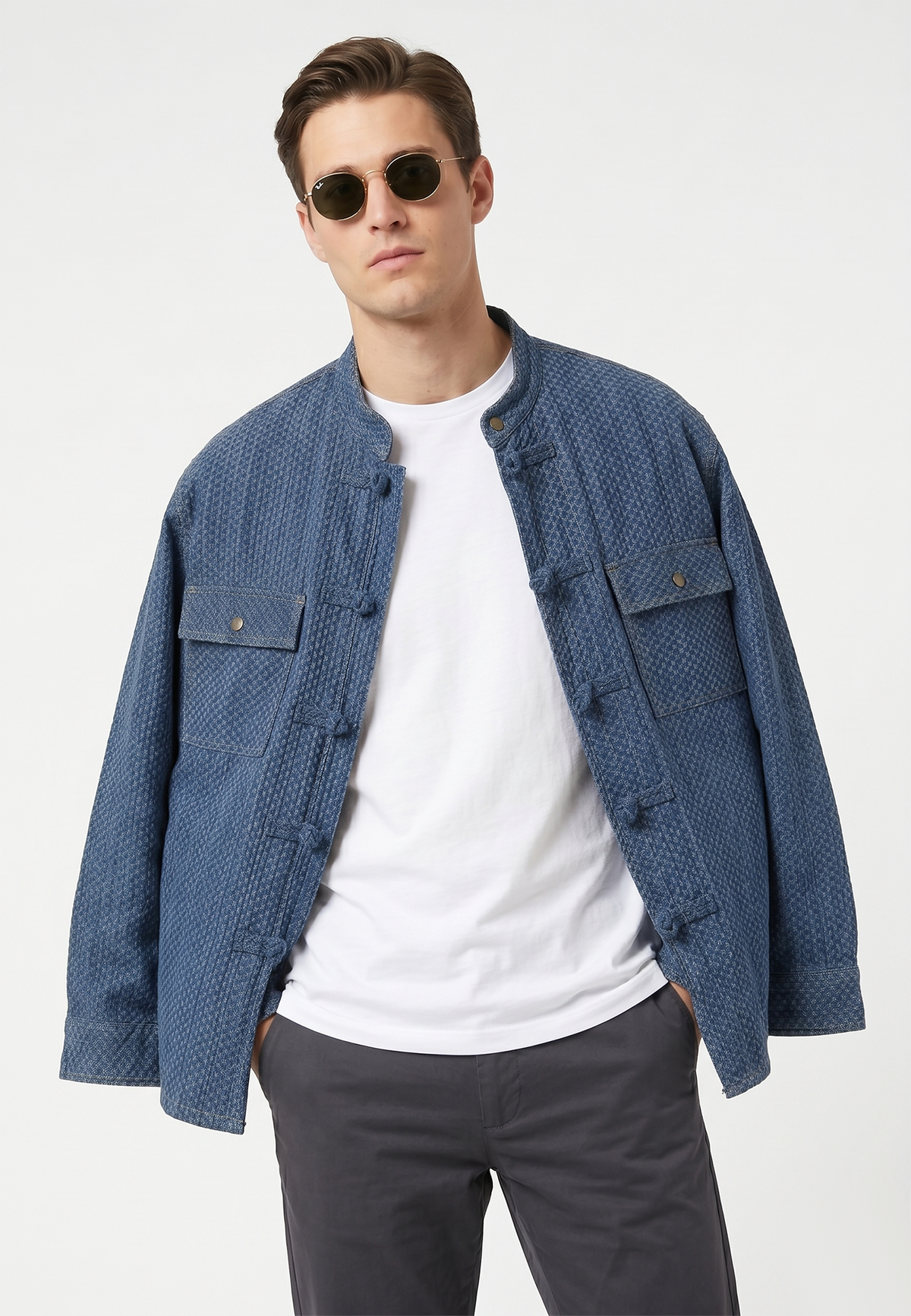 Man wearing a blue textured jacket over a white shirt on a white background